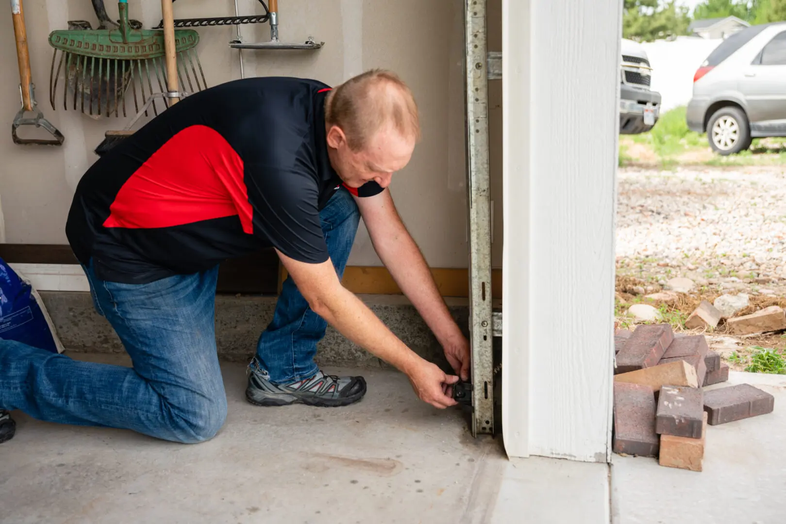 A man is fixing the door of his garage.