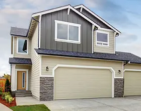 A house with two garage doors and a driveway.