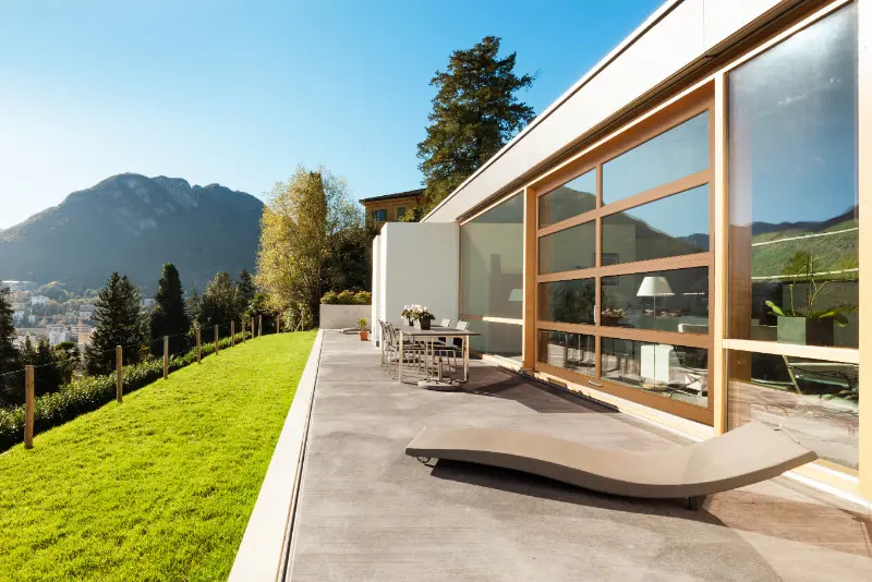 A patio with chairs and tables outside of it