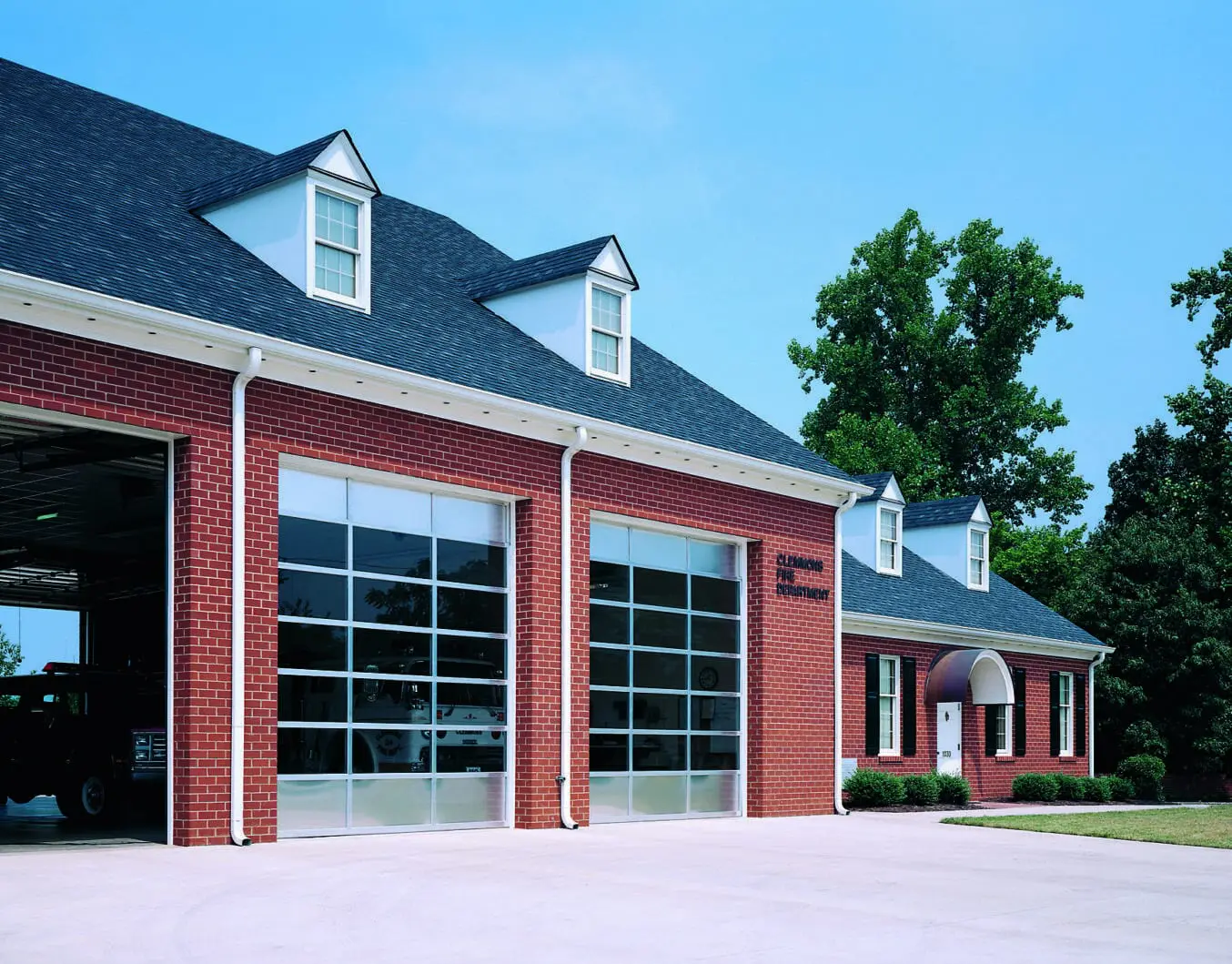 A red brick building with two large windows.