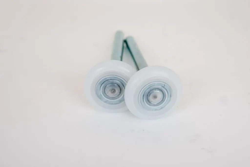 A pair of white wheels with metal stems.