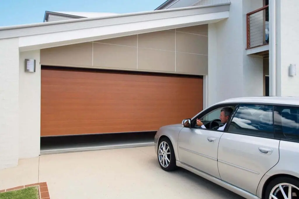 A car parked in front of a garage door.