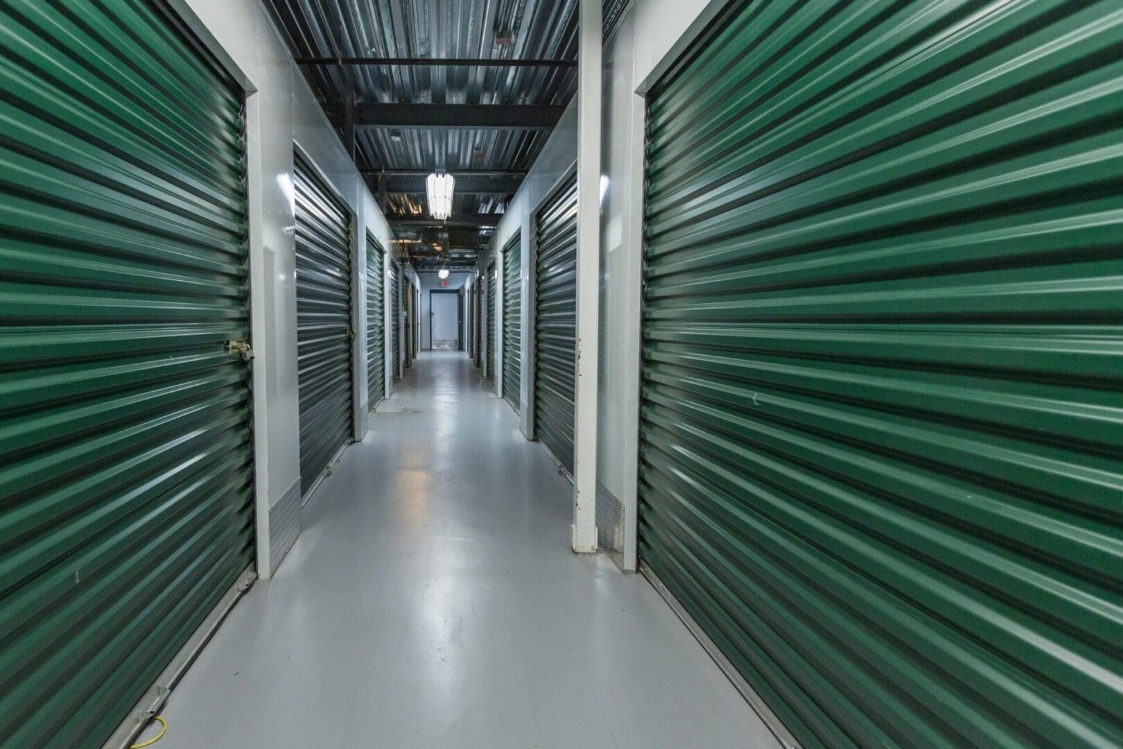 A long hallway with many green doors
