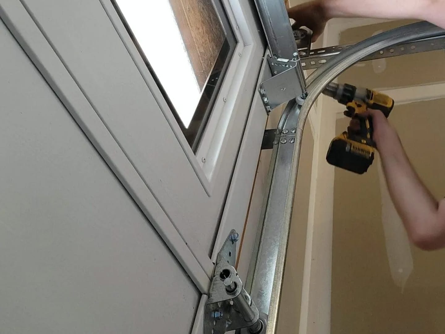 A man working on the inside of a garage door.