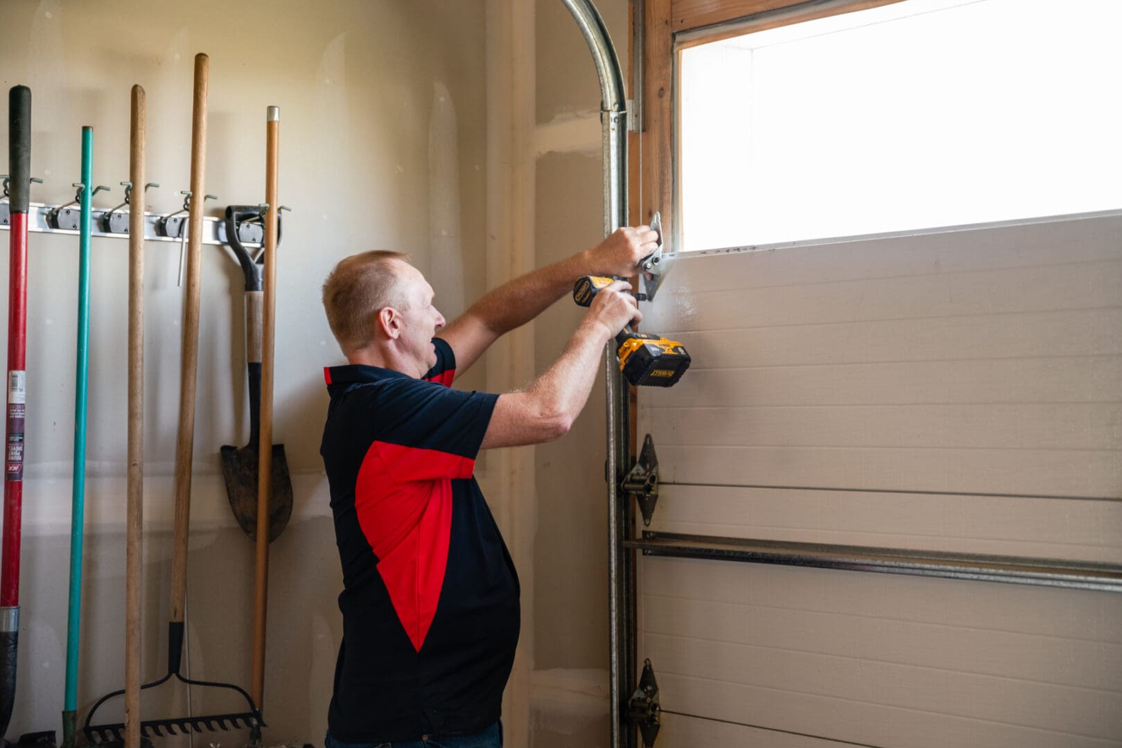 Beacon Garage Doors technician repairing a residential garage door in North Ogden, Utah.