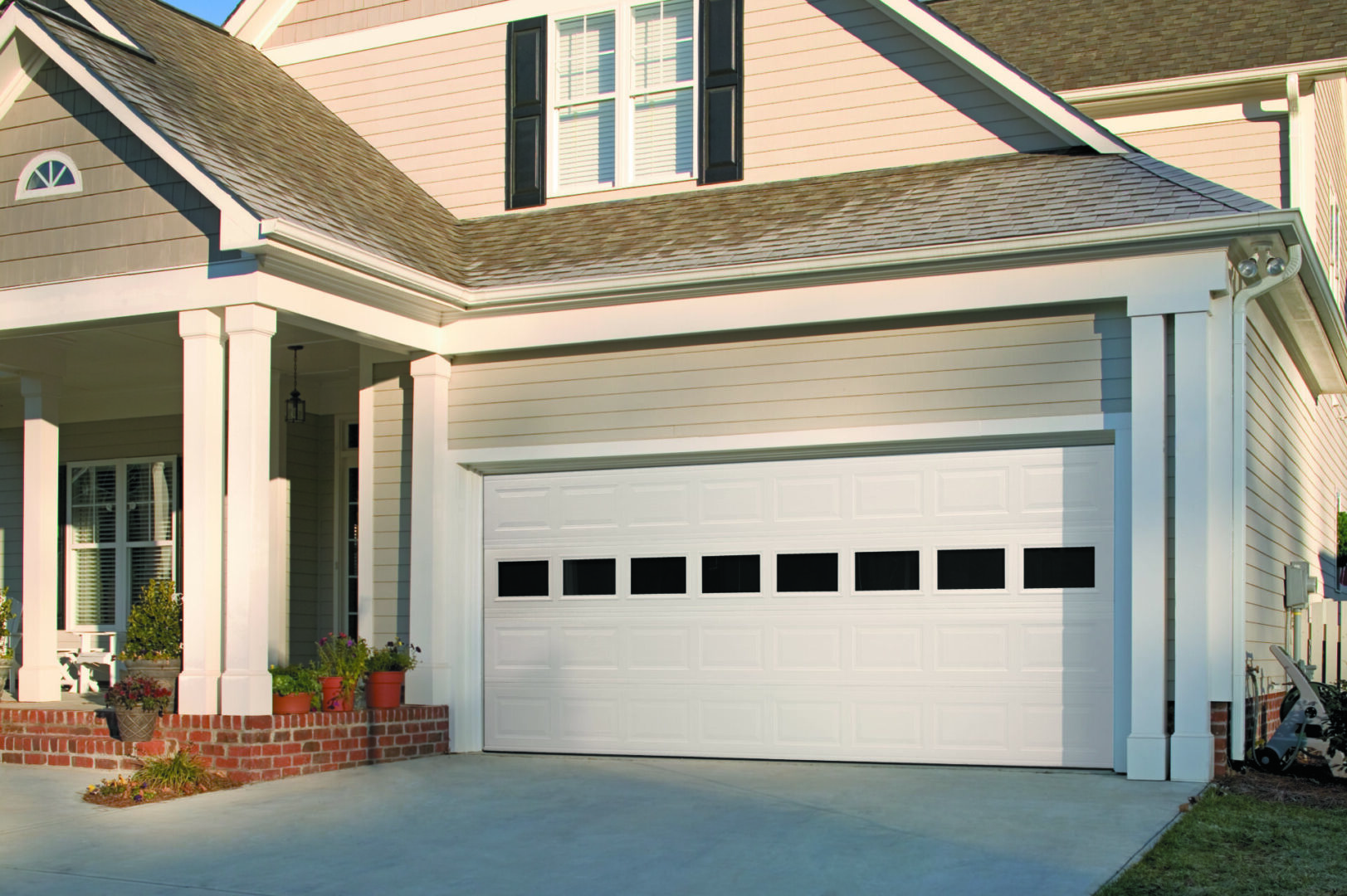 A white garage door in front of a house.