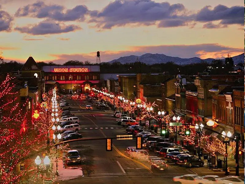 A city street with many cars parked on the side of it.