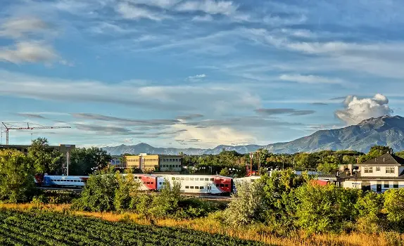 A train is traveling through the countryside near mountains.