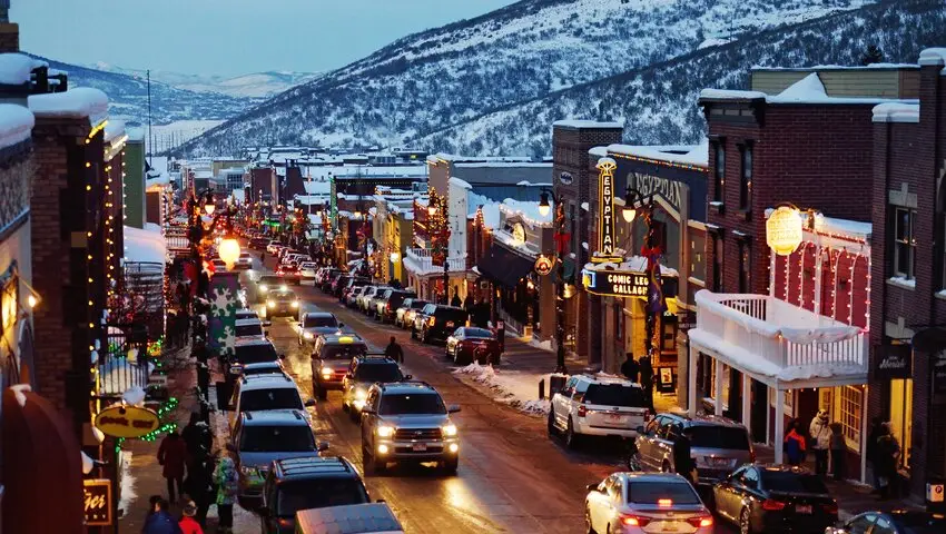 A busy street with cars parked on the side of it.