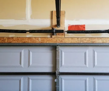 Broken garage door torsion spring above a sectional garage door – spring repair needed in Riverdale, UT