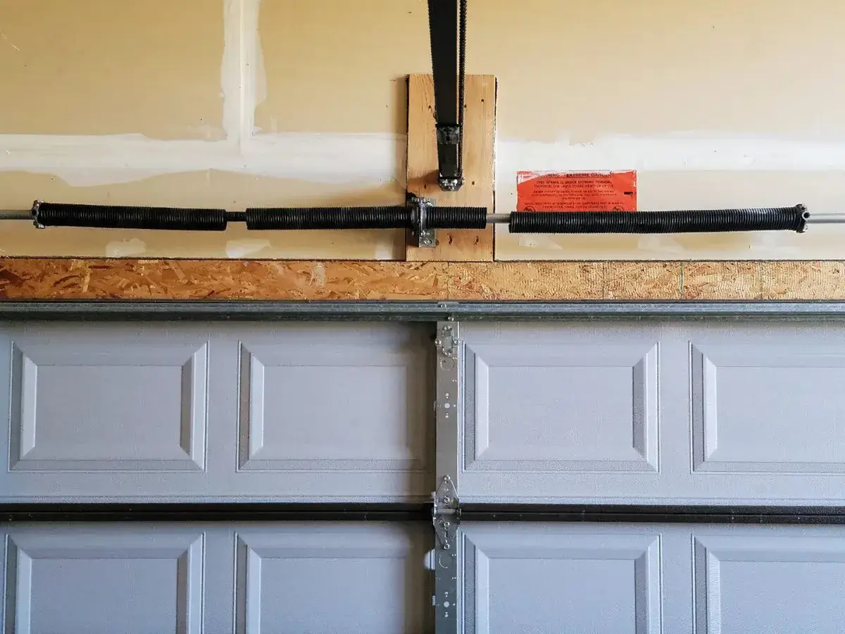 Broken garage door torsion spring above a sectional garage door – spring repair needed in Riverdale, UT