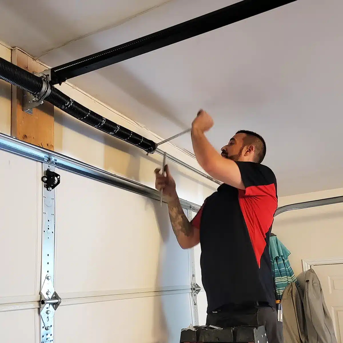 Technician repairing a garage door torsion spring in Layton, Utah – Beacon Garage Doors